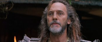 Movie still from “No Escape” (1994), directed by Martin Campbell – A person with long hair; Close Up shot, Low angle