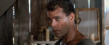 Movie still from “No Escape” (1994), directed by Martin Campbell – A person with a serious look on his face; Close Up shot, Low angle