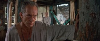 Movie still from “No Escape” (1994), directed by Martin Campbell – A person with a knife in his hand; Close Up shot, Low angle