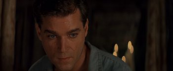 Movie still from “No Escape” (1994), directed by Martin Campbell – A man's face with a candle in the background; Close Up shot, High angle