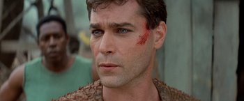 Movie still from “No Escape” (1994), directed by Martin Campbell – A person with a scar on his face; Close Up shot, Low angle