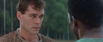 Movie still from “No Escape” (1994), directed by Martin Campbell – A person with blue eyes looking at another person; Close Up shot, Over the shoulder angle