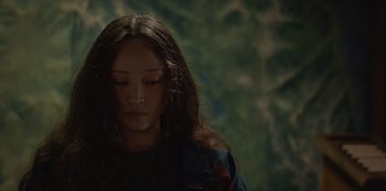 Movie still from “No Exit” (2022), directed by Damien Power – A young woman with long hair is looking at the camera; Close Up shot, High angle