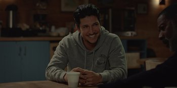 Movie still from “No Exit” (2022), directed by Damien Power – A man sitting at a table with a cup of coffee; Close Up shot, Over the shoulder angle