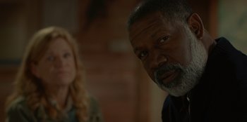 Movie still from “No Exit” (2022), directed by Damien Power – An older man and a younger woman are looking at the camera; Close Up shot, Over the shoulder angle