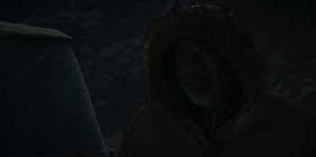 Movie still from “No Exit” (2022), directed by Damien Power – A man with a beard and a fur lined jacket; Close Up shot, Over the shoulder angle