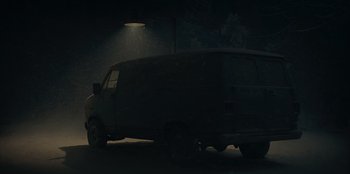 Movie still from “No Exit” (2022), directed by Damien Power – A van parked under a street light at night; Extreme Wide shot, Low angle
