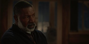 Movie still from “No Exit” (2022), directed by Damien Power – An older man with a gray beard looking at the camera; Close Up shot, Over the shoulder angle