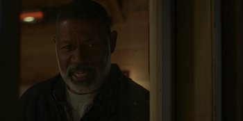 Movie still from “No Exit” (2022), directed by Damien Power – An older black man looking out of a window; Close Up shot, Over the shoulder angle