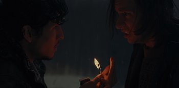 Movie still from “No Exit” (2022), directed by Damien Power – Two people are lighting a candle in the dark; Close Up shot, Over the shoulder angle