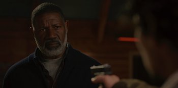 Movie still from “No Exit” (2022), directed by Damien Power – An older man holding a cell phone in his hand; Close Up shot, Over the shoulder angle