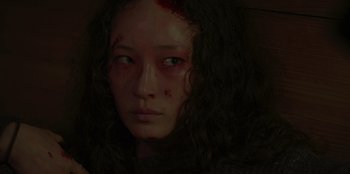 Movie still from “No Exit” (2022), directed by Damien Power – A young woman with a bruised face and red eyes; Close Up shot, Over the shoulder angle