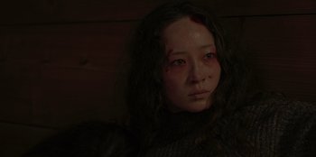 Movie still from “No Exit” (2022), directed by Damien Power – A young woman with a bruised face and red eyes; Close Up shot, Low angle