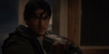 Movie still from “No Exit” (2022), directed by Damien Power – A person holding a gun; Close Up shot, Low angle