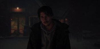 Movie still from “No Exit” (2022), directed by Damien Power – A man in a hooded jacket standing in the snow; Close Up shot, Over the shoulder angle