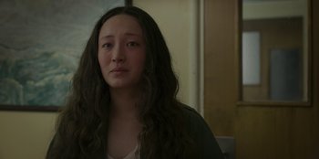 Movie still from “No Exit” (2022), directed by Damien Power – A woman with long black hair is looking at the camera; Close Up shot, Over the shoulder angle