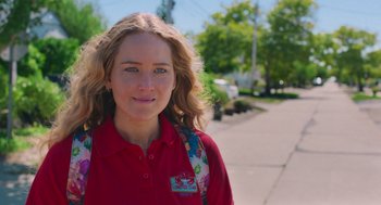 Movie still from “No Hard Feelings” (2023), directed by Gene Stupnitsky – A woman with a backpack standing on the side of the road; Close Up shot, Over the shoulder angle