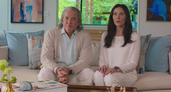 Movie still from “No Hard Feelings” (2023), directed by Gene Stupnitsky – A man and a woman sitting on a white couch; Medium shot, Over the shoulder angle