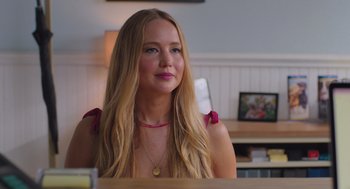 Movie still from “No Hard Feelings” (2023), directed by Gene Stupnitsky – A beautiful young lady sitting at a table in a room; Close Up shot, Over the shoulder angle