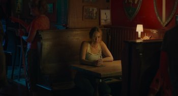 Movie still from “No Hard Feelings” (2023), directed by Gene Stupnitsky – A woman sitting at a table in a restaurant; Medium shot, High angle