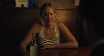 Movie still from “No Hard Feelings” (2023), directed by Gene Stupnitsky – A woman sitting at a table with a bottle of milk; Close Up shot, Over the shoulder angle