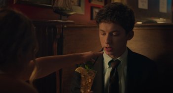 Movie still from “No Hard Feelings” (2023), directed by Gene Stupnitsky – A man in a suit and tie holding a drink; Medium shot, Over the shoulder angle