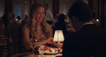 Movie still from “No Hard Feelings” (2023), directed by Gene Stupnitsky – A beautiful young lady sitting at a dinner table; Medium shot, Over the shoulder angle