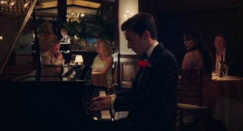Movie still from “No Hard Feelings” (2023), directed by Gene Stupnitsky – A man in a suit playing piano in a restaurant; Medium shot, Over the shoulder angle