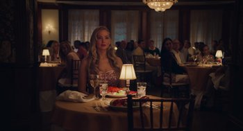 Movie still from “No Hard Feelings” (2023), directed by Gene Stupnitsky – A woman sitting at a table with a plate of food; Medium shot, Over the shoulder angle