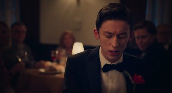 Movie still from “No Hard Feelings” (2023), directed by Gene Stupnitsky – A man in a suit and bow tie looking down; Close Up shot, Over the shoulder angle