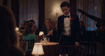Movie still from “No Hard Feelings” (2023), directed by Gene Stupnitsky – A man in a tuxedo standing in front of a table; Medium shot, Over the shoulder angle