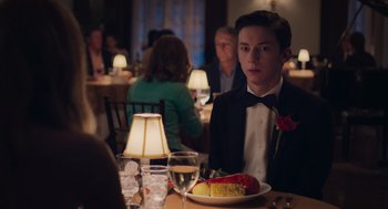 Movie still from “No Hard Feelings” (2023), directed by Gene Stupnitsky – A man sitting at a table with a plate of food; Medium shot, Over the shoulder angle