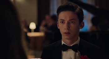 Movie still from “No Hard Feelings” (2023), directed by Gene Stupnitsky – A young man in a suit and bow tie looking at the camera; Close Up shot, Over the shoulder angle