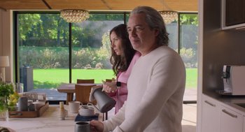 Movie still from “No Hard Feelings” (2023), directed by Gene Stupnitsky – A man and a woman standing next to each other in a room; Medium shot, Low angle