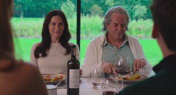 Movie still from “No Hard Feelings” (2023), directed by Gene Stupnitsky – A man and a woman sitting at a table with a glass of red wine; Medium shot, Over the shoulder angle