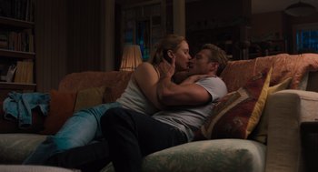 Movie still from “No Hard Feelings” (2023), directed by Gene Stupnitsky – A man and a woman kissing on a couch; Medium shot, High angle