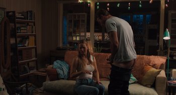 Movie still from “No Hard Feelings” (2023), directed by Gene Stupnitsky – A man and a woman sitting on a couch in a living room; Medium shot, Over the shoulder angle