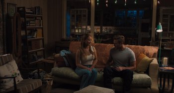 Movie still from “No Hard Feelings” (2023), directed by Gene Stupnitsky – A man and a woman are sitting on a couch; Wide shot, Over the shoulder angle