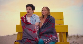 Movie still from “No Hard Feelings” (2023), directed by Gene Stupnitsky – A man and a woman sitting on a bench wrapped in a blanket; Medium shot, High angle