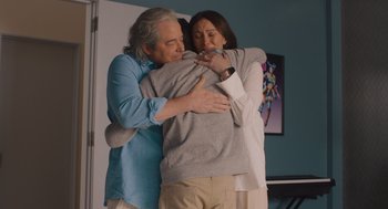 Movie still from “No Hard Feelings” (2023), directed by Gene Stupnitsky – A man and a woman hugging in a living room; Medium shot, Low angle
