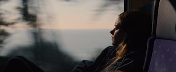 Movie still from “No Limit” (2022), directed by David M. Rosenthal – A woman looking out of a window at the ocean; Close Up shot, High angle