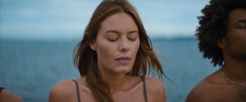 Movie still from “No Limit” (2022), directed by David M. Rosenthal – A woman with her eyes closed with her hair blowing in the wind; Close Up shot, High angle