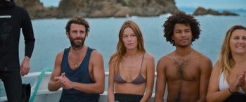 Movie still from “No Limit” (2022), directed by David M. Rosenthal – A group of people standing next to a body of water; Medium shot, High angle