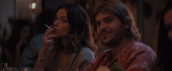 Movie still from “No Limit” (2022), directed by David M. Rosenthal – A woman smoking a cigarette next to a bearded man; Close Up shot, Over the shoulder angle