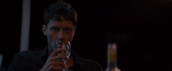 Movie still from “No Limit” (2022), directed by David M. Rosenthal – A man holding a wine glass in front of a wine bottle; Close Up shot, Over the shoulder angle