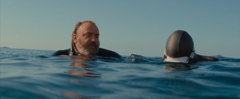 Movie still from “No Limit” (2022), directed by David M. Rosenthal – A man and a woman in the water; Close Up shot, Low angle