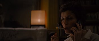 Movie still from “No Limit” (2022), directed by David M. Rosenthal – A woman is smoking a cigarette in a room; Close Up shot, Low angle