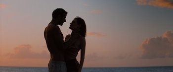Movie still from “No Limit” (2022), directed by David M. Rosenthal – A man and a woman standing next to each other on the beach; Medium shot, Low angle