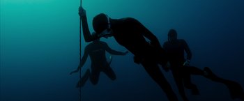 Movie still from “No Limit” (2022), directed by David M. Rosenthal – A group of scuba divers swimming in the ocean; Wide shot, Low angle