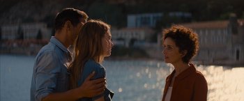 Movie still from “No Limit” (2022), directed by David M. Rosenthal – Two women and a man standing next to each other near a body of water; Medium shot, Over the shoulder angle